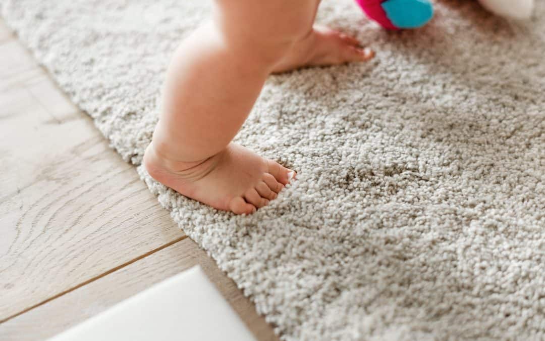 Baby standing on clean white carpet