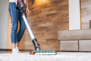a woman vacuuming her carpet