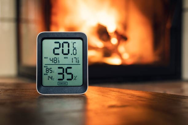digital thermometer checking the temperature of a fireplace