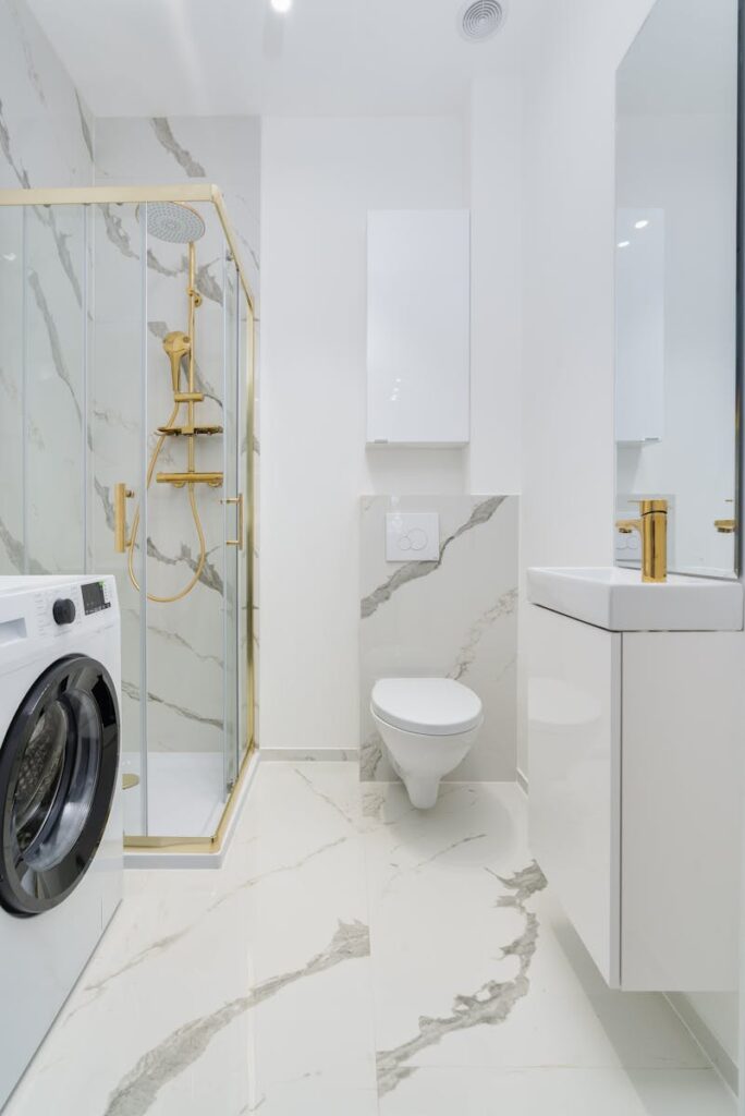Bright, contemporary bathroom with marble accents and gold fixtures. Ideal for interior design inspiration.
