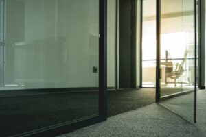 Contemporary office space with glass doors and minimalist design elements.