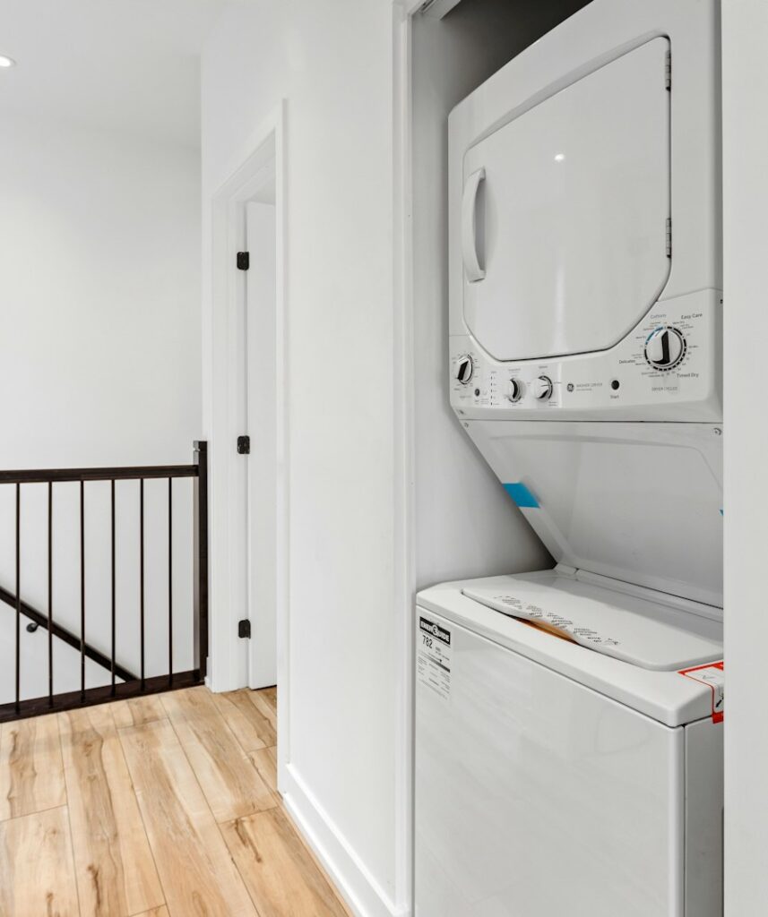 a white room with a mirror and a washer